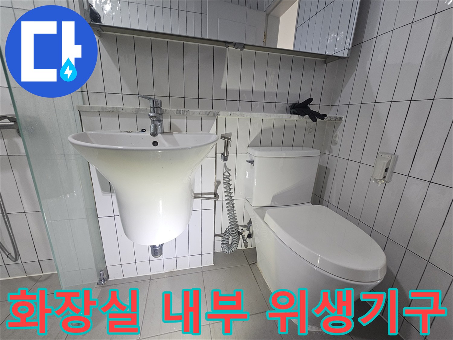 타일 벽에 설치된 깨끗한 상태의 변기와 세면대 사진입니다.