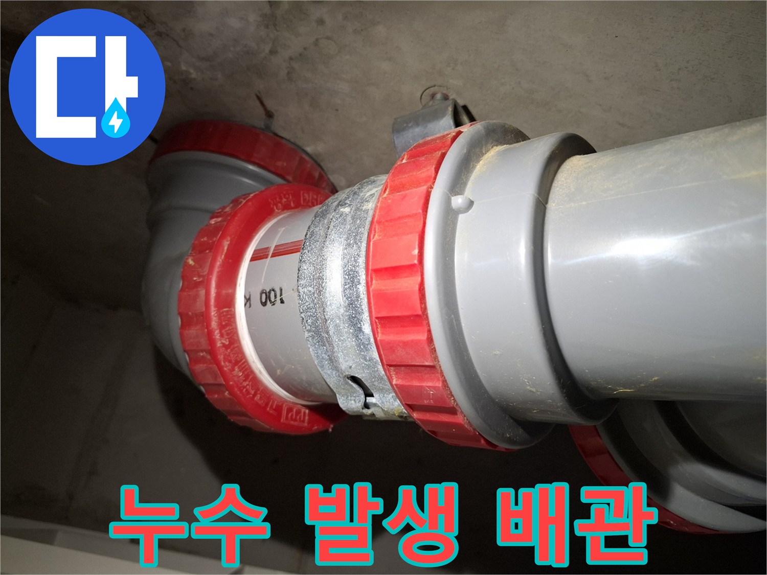 천장 배관의 붉은색 패킹 부위와 회색 PVC 관로 연결 상태