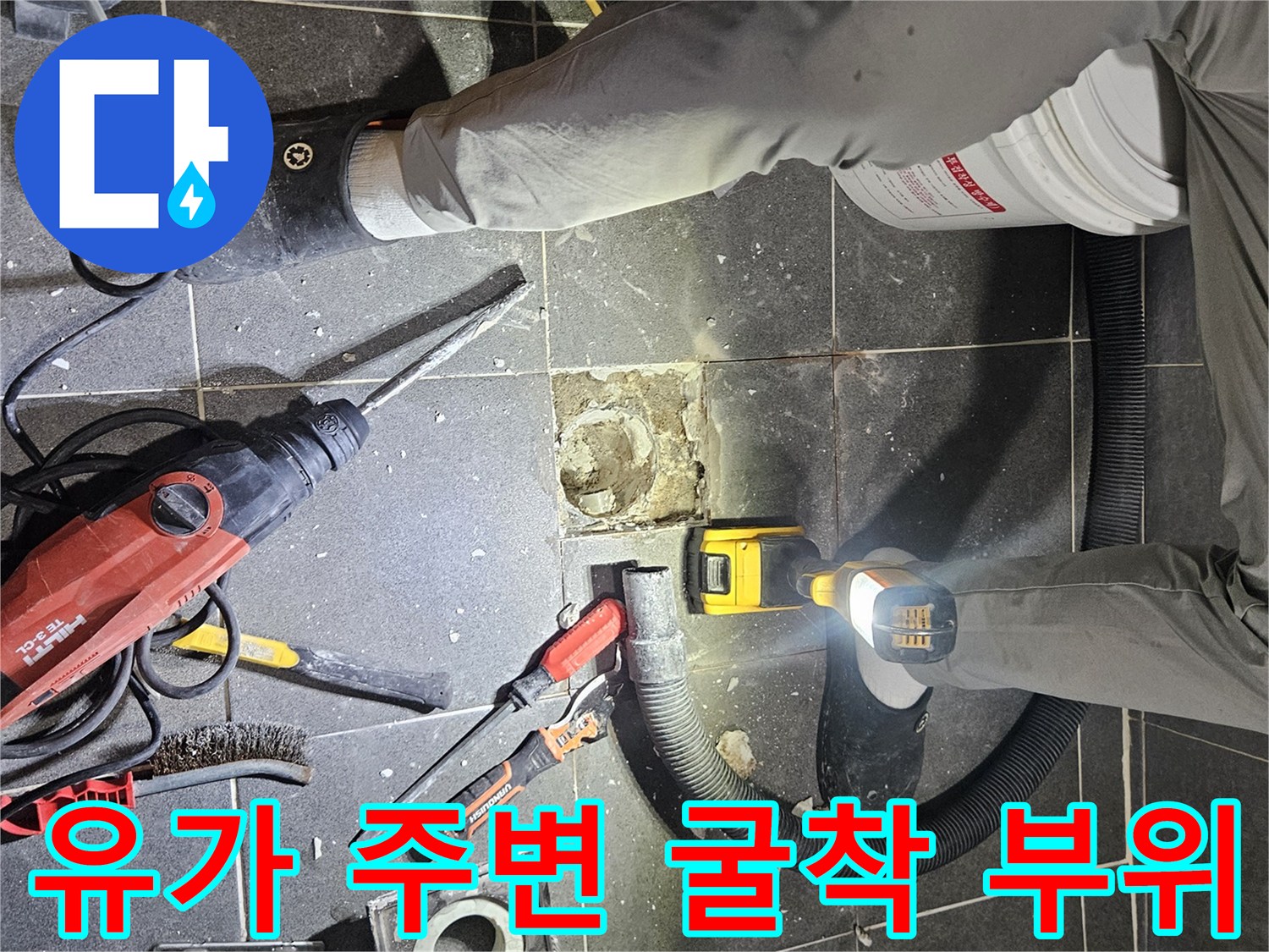 화장실 배수구 유가 근처의 타일을 제거하고 내부를 노출시킨 모습