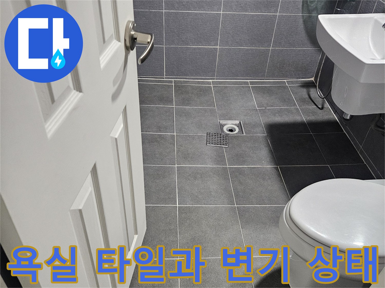 회색 타일로 마감된 욕실 내부와 하얀색 양변기 모습