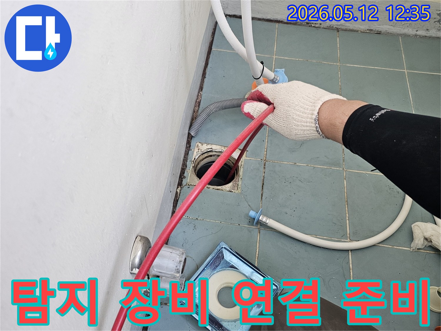 누수 엔지니어가-장갑을 끼고-누수 탐지 장비 연결을 위해-배관을 준비하는-세심한 작업 현장