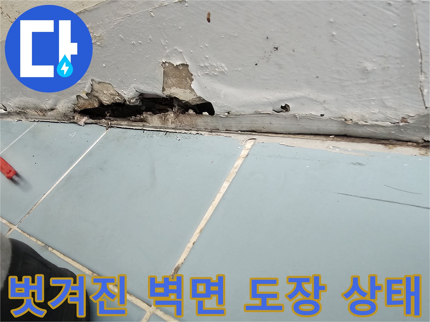 세탁실 하단부의 페인트 박리와 틈새 균열을 근접 촬영한 사진