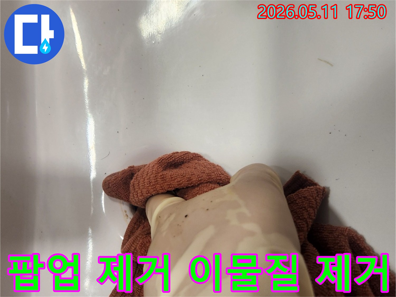 누수 공사 중 팝업을 제거하고- 배수구의 이물질을 깨끗하게 제거하는 과정입니다