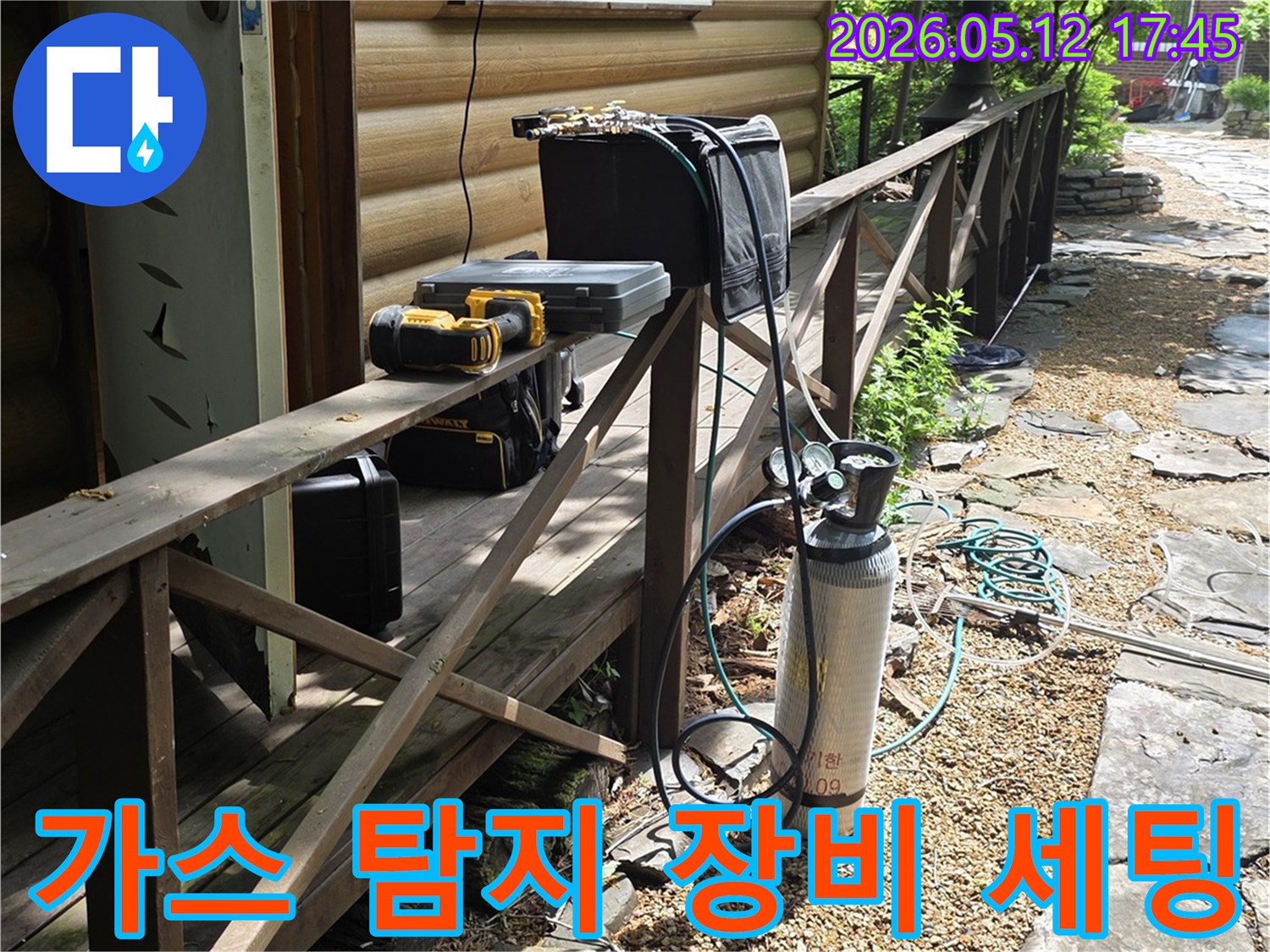 빌라 외벽 옆-누수 탐지용 가스통과-장비들이 놓여있는 장면