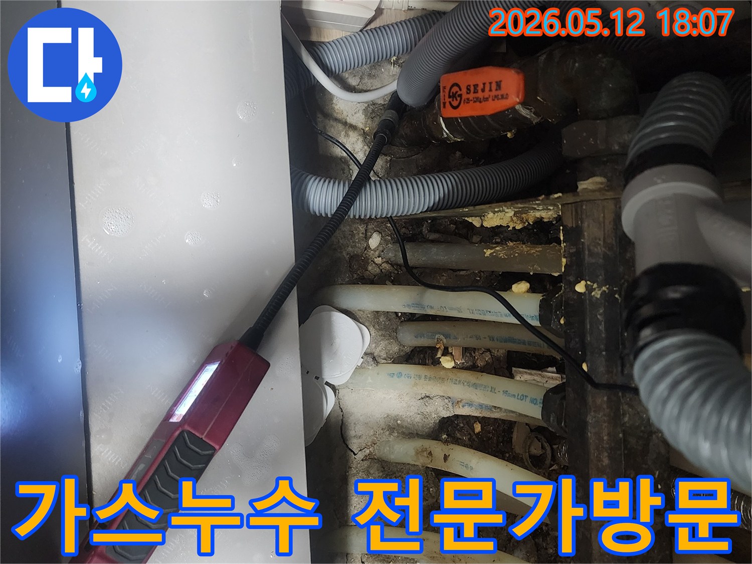 가스누수 탐지 전문가가 보일러 배관 주변을 정밀 탐지기로 검사하는 모습