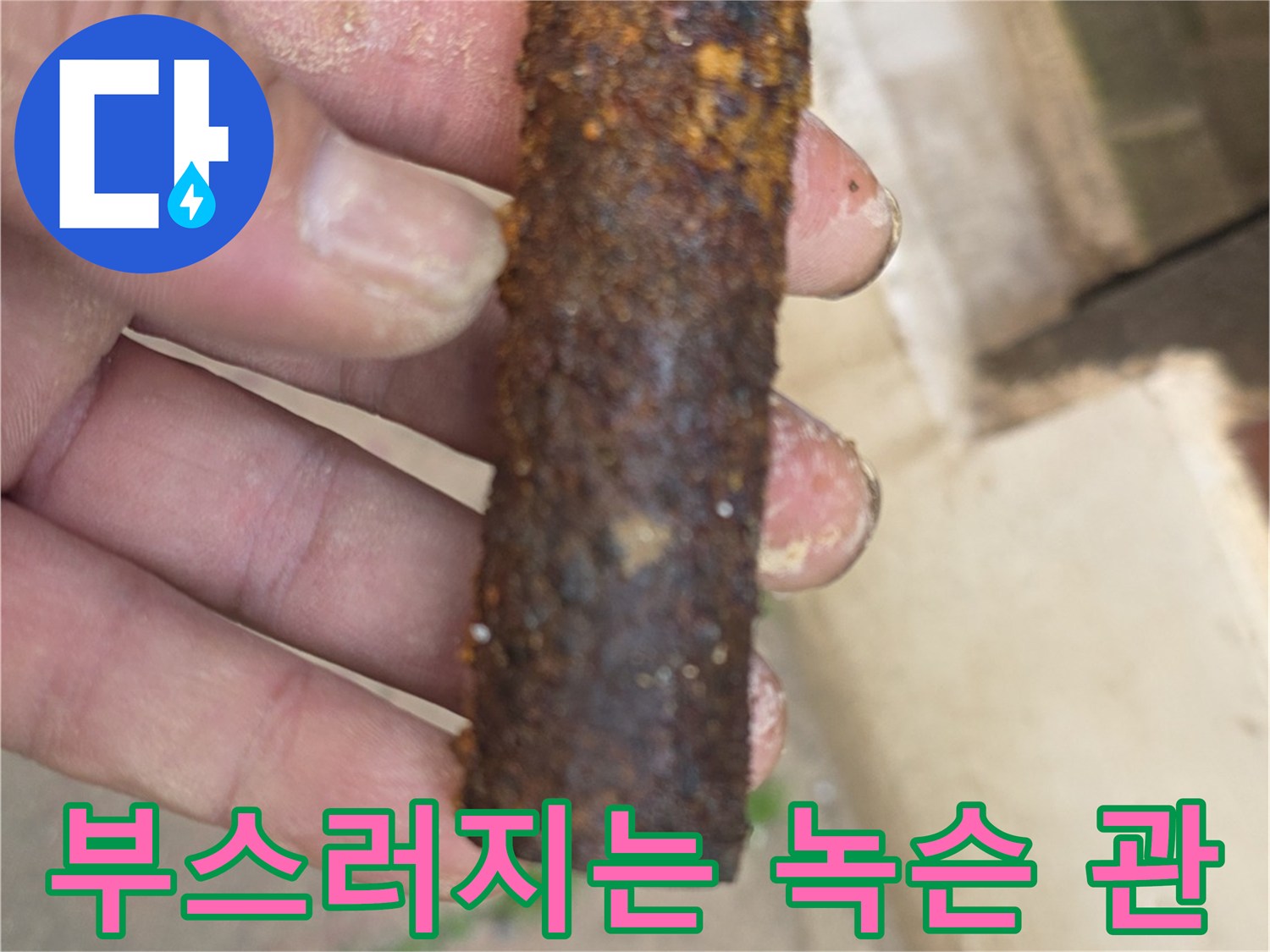 손가락으로 잡은-심하게 부식된-노후 철배관