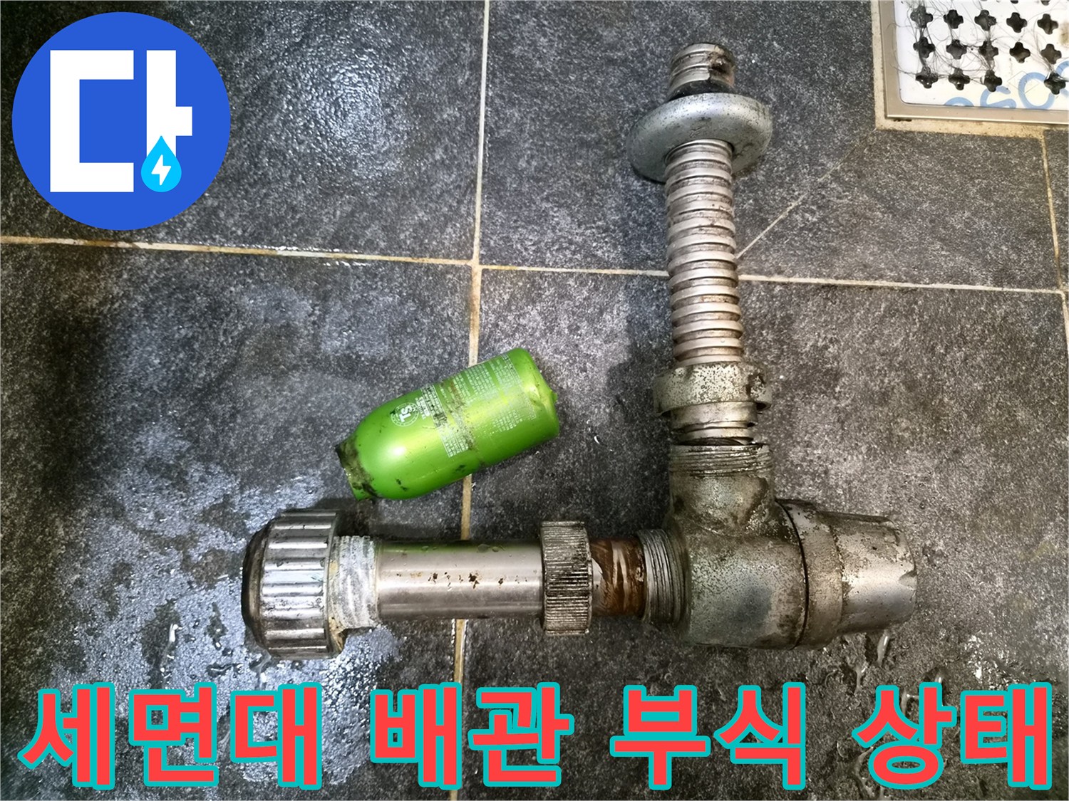 부식된 세면대 트랩과 연결 부위의 노후 상태를 보여주는 사진입니다.