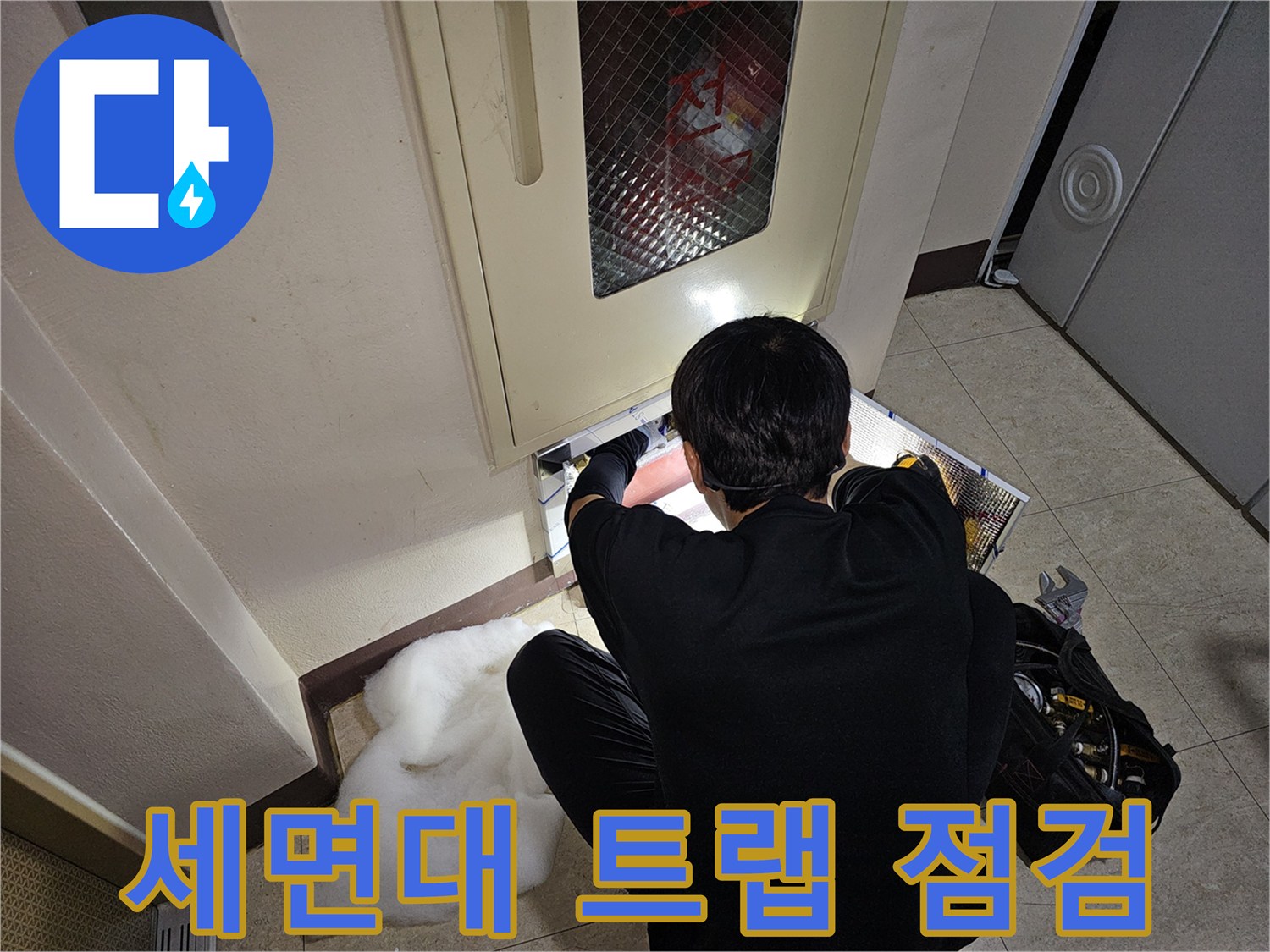 세면대 하단 배관 연결 부위의 누수 여부를 검사하는 장면