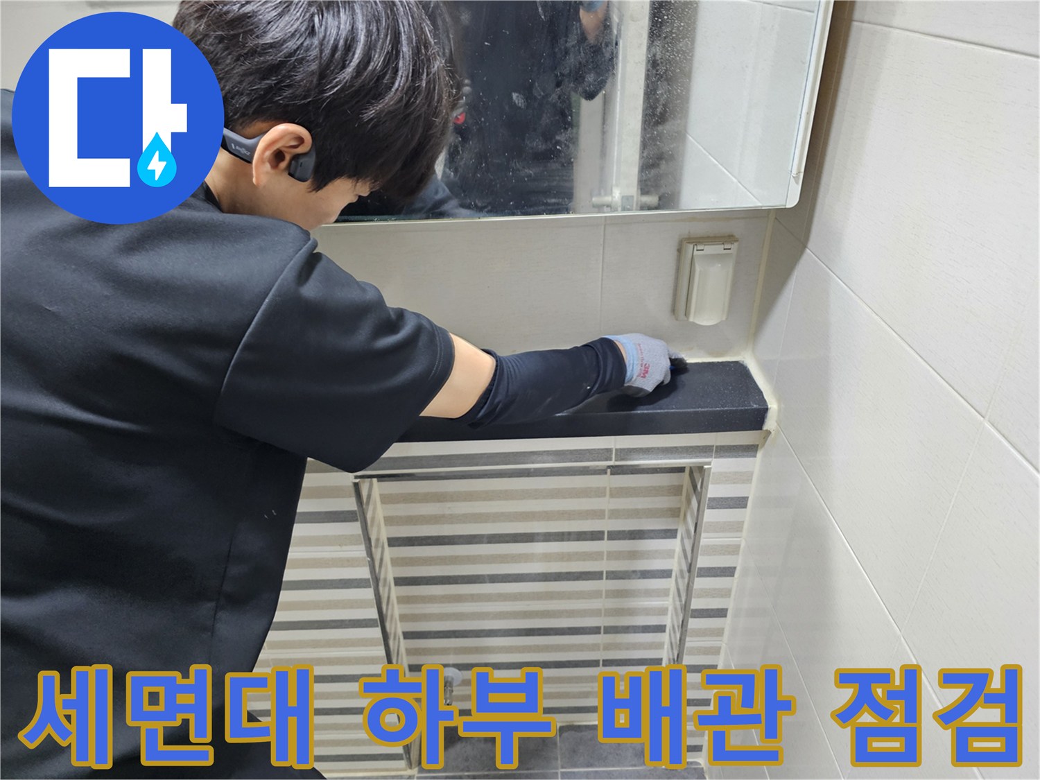 엔지니어가 세면대 하부 트랩과 연결 부위를 손으로 만지며 누수 여부를 확인하고 있습니다.