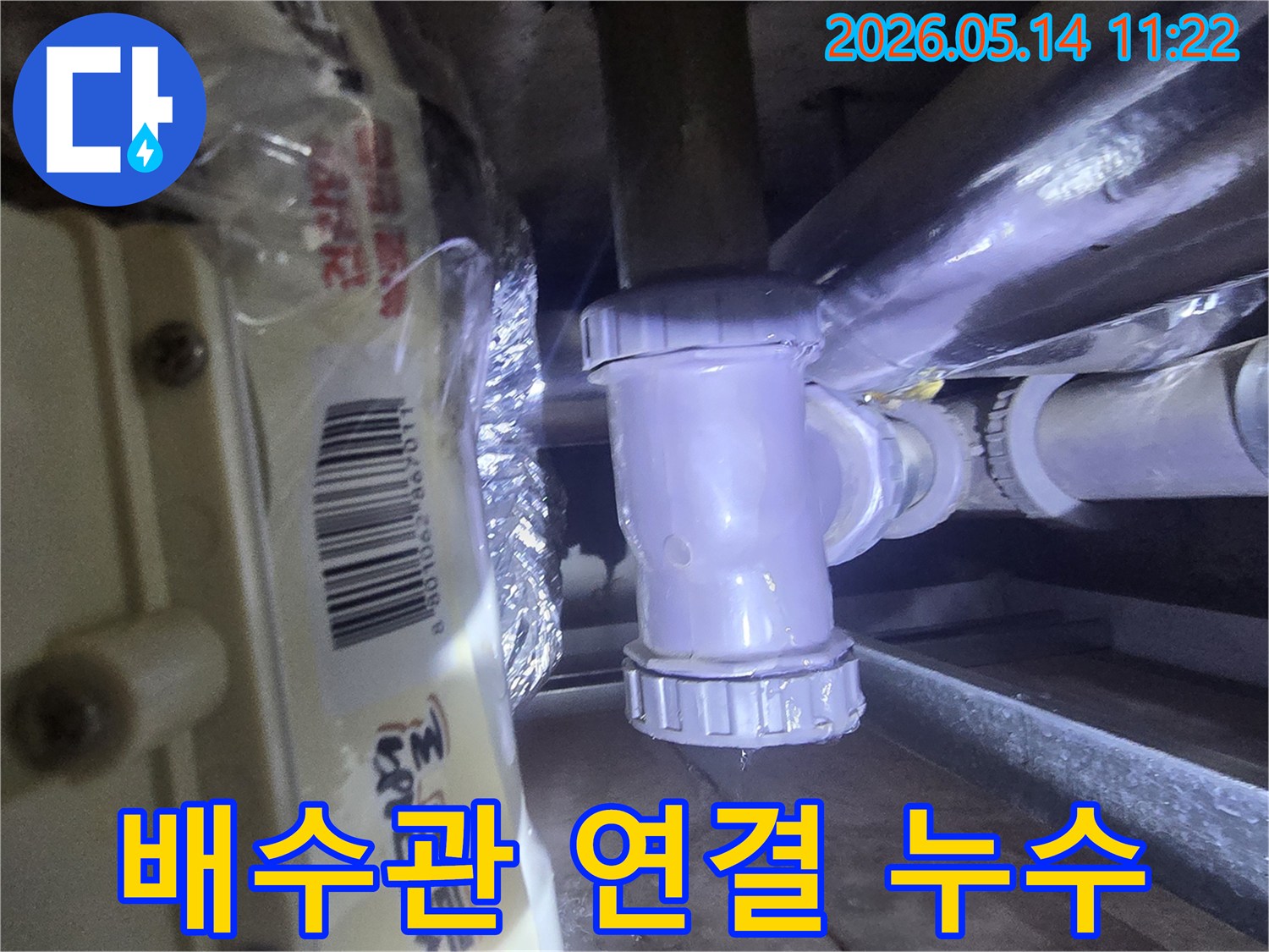 배수관 연결 부위에서-물이 새는 현장을-전문가가 면밀히-검토하고 있는-사진입니다