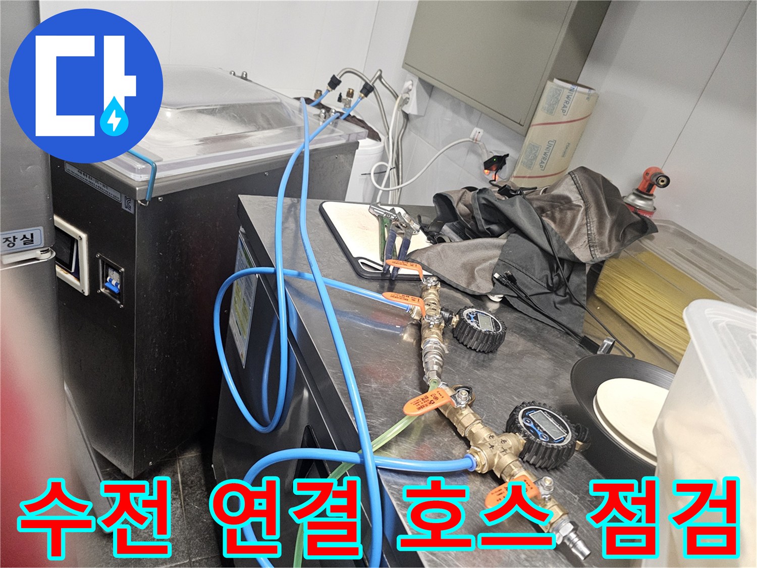 싱크대 하부의 파란색 급수 호스와 금속 밸브 부위를 정밀하게 관찰하는 장면입니다.