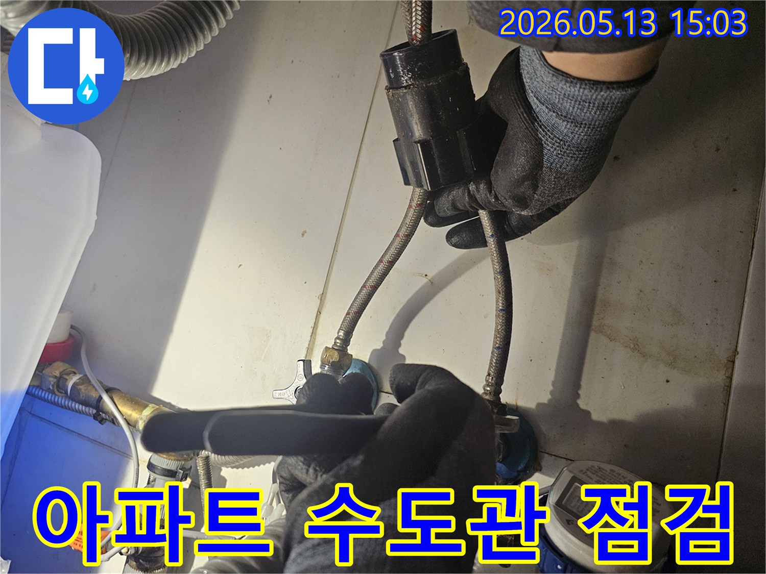 전문가가-아파트 내부의-수도관 연결 부위를-꼼꼼하게 점검하며-누수 흔적을-찾아내고 있습니다