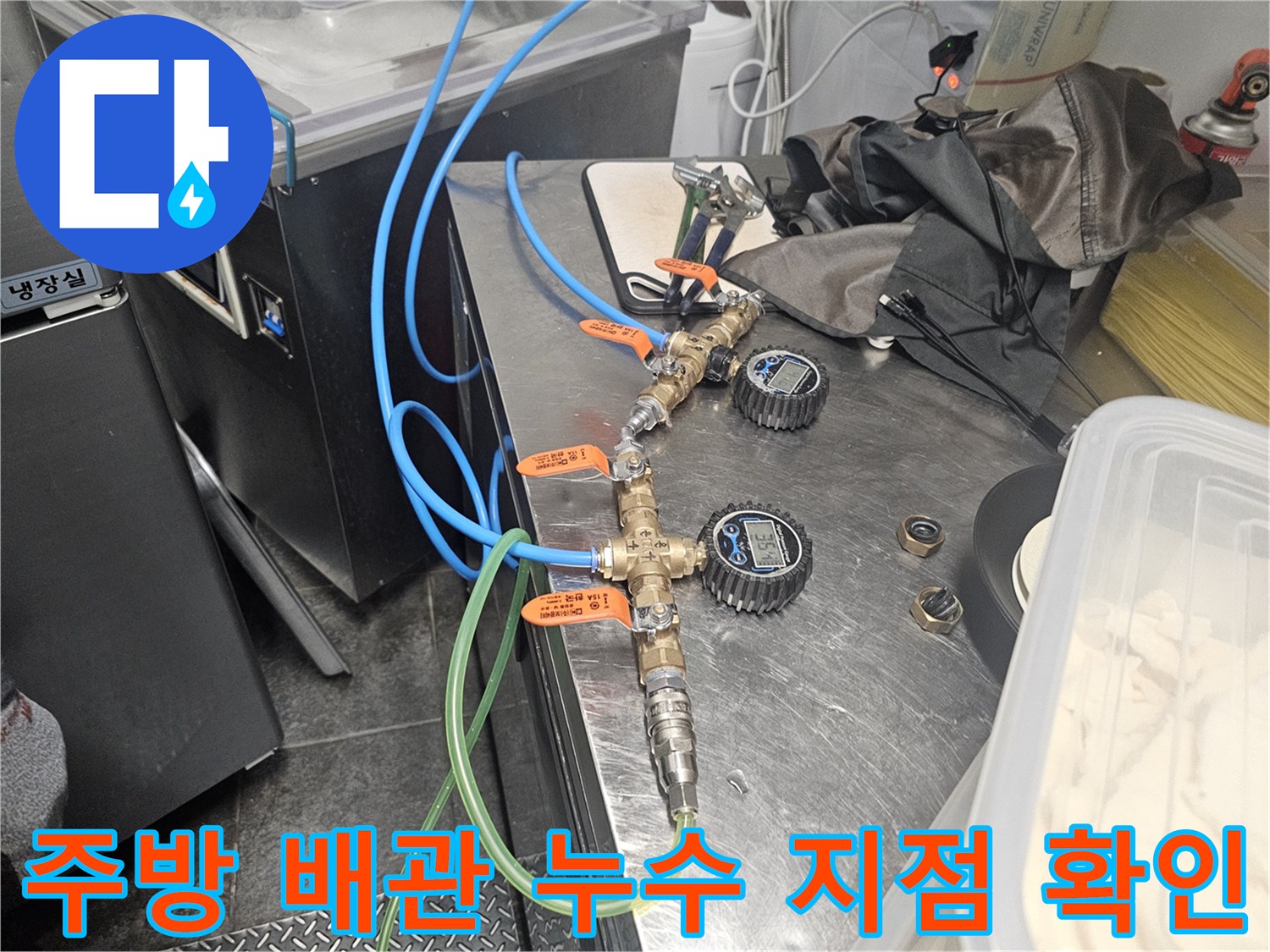 주방 싱크대 하단의 밸브와 연결된 유연한 호스 부위