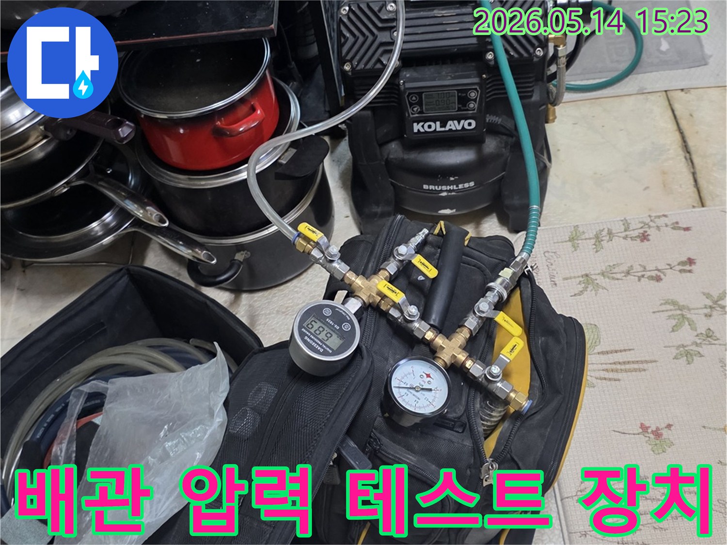 누수 탐지를 위해 배관에 연결된 압력 테스트 장비와 게이지