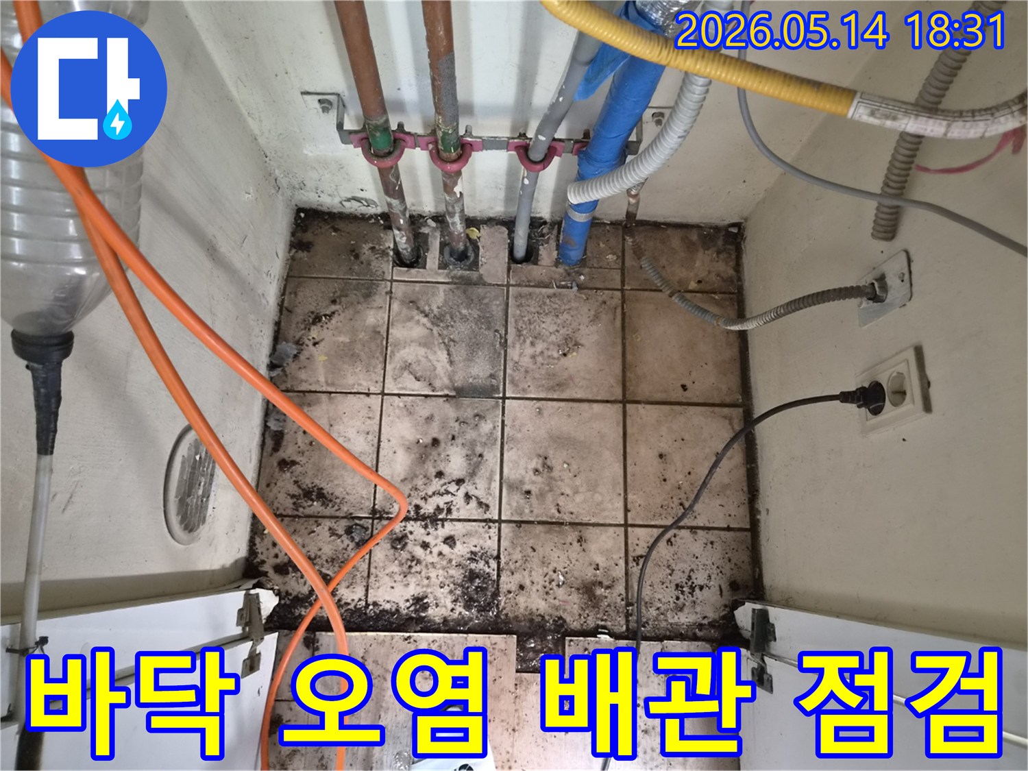 누수로 인해 지저분해진 바닥과-다양한 배관들이 설치된-하남 아파트의 누수 점검 현장