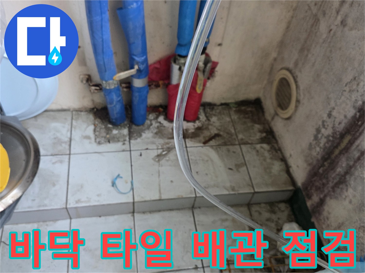주방 바닥 타일과 파란색 배관 연결 부위 상세 사진