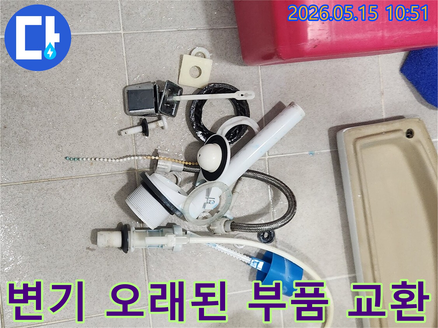 오랜 사용으로 기능이 저하된 변기 부속품들이-바닥에 놓여-새 부품으로 교체될 준비를 하고 있습니다
