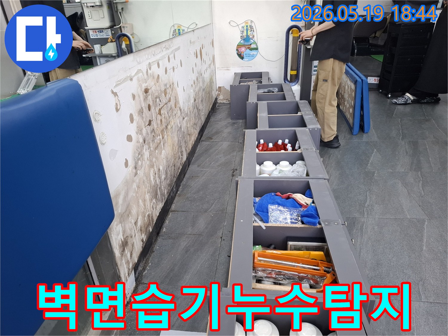 습기로 인해 얼룩지고 손상된 벽면과-누수 탐지를 위해 준비된 공간-그리고 현장을 면밀히 살피는 엔지니어의 모습