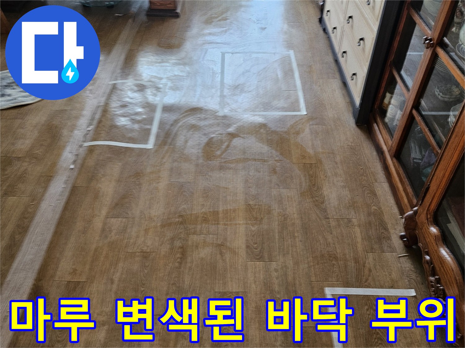 습기 침투로 인한 거실 마루의 어두운 얼룩과 변색 상태