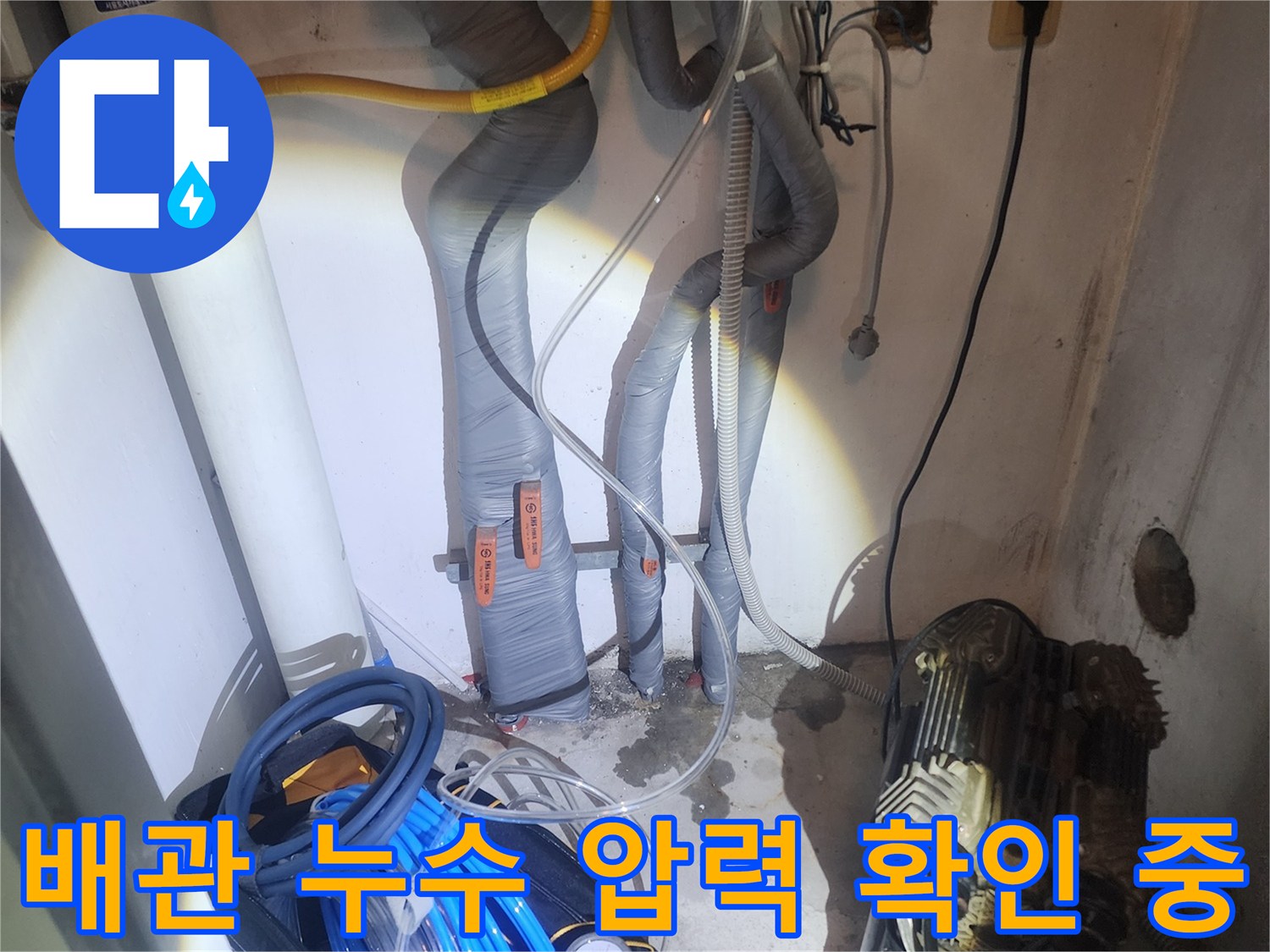전문가가 누수 지점을 정확히 찾기 위해-공압 장비를 사용하여 배관 압력을 정밀하게 측정하는 모습