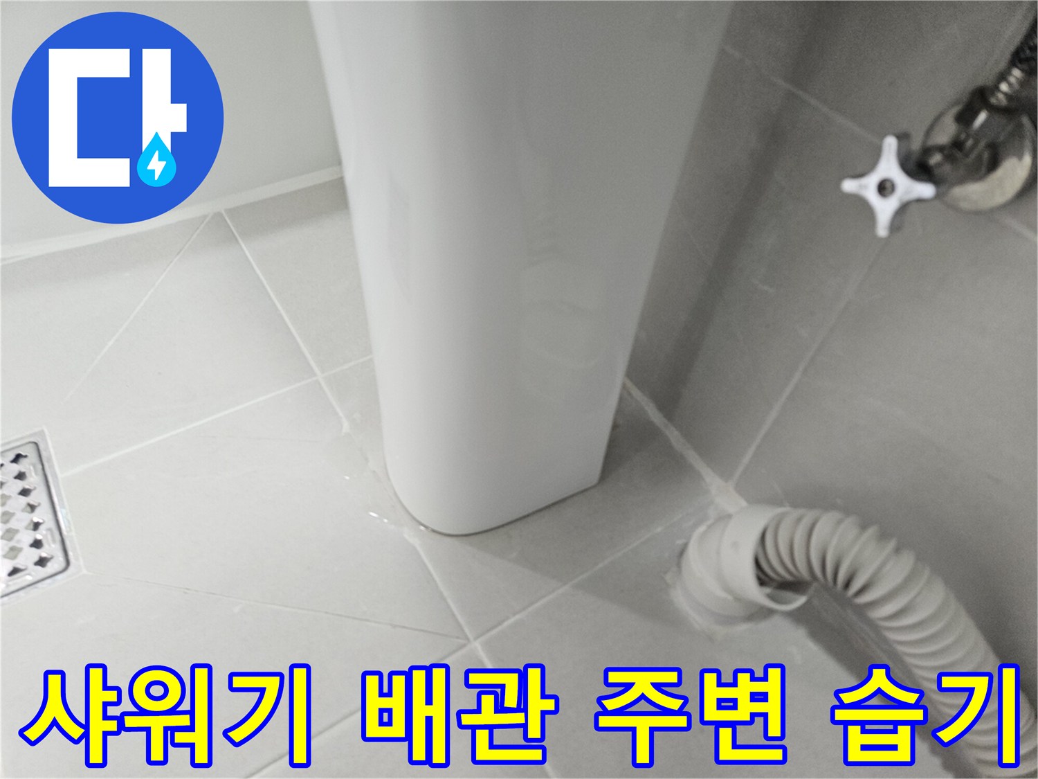 하얀색 타일 벽면에 샤워기 헤드와 배관이 연결된 모습입니다.