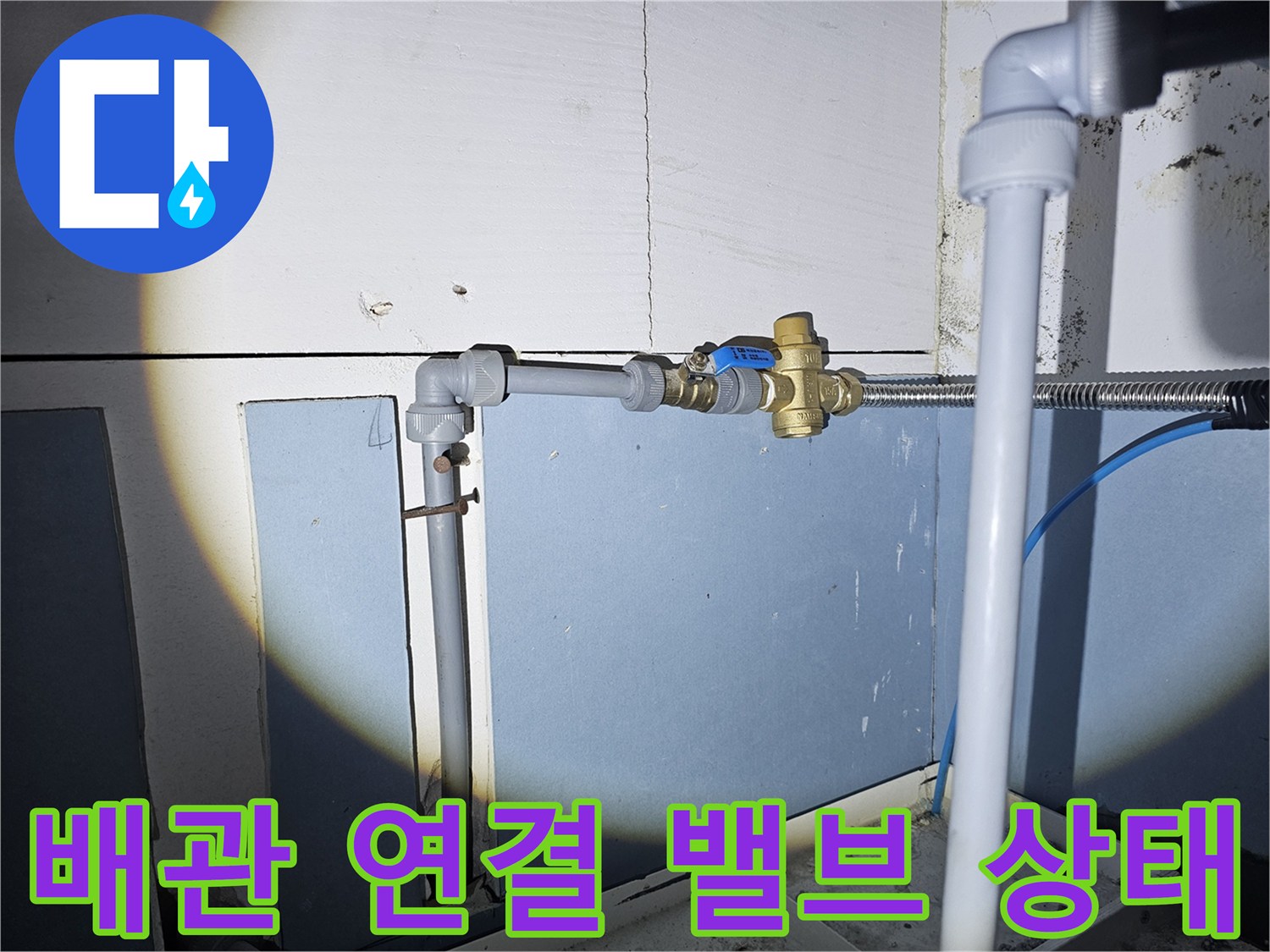 온수기 하단 - 배관 및 황동색 밸브 연결 부위