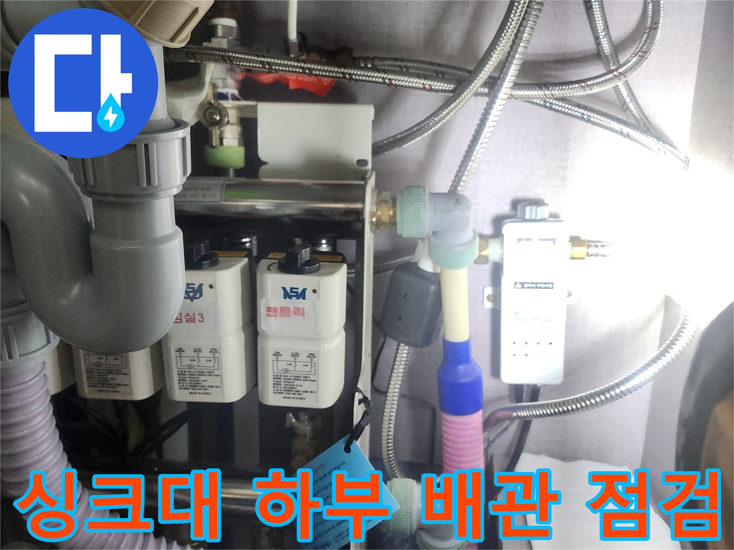 싱크대-하부장-내부의-복잡한-배관과-수전-연결-상태를-확인하는-모습