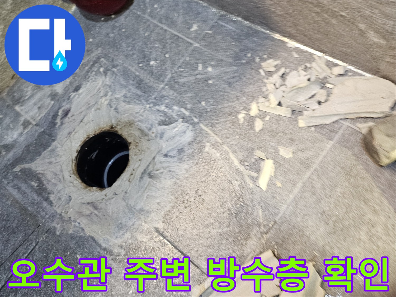 변기 탈거 후 노출된-배관 입구 주변의 젖어 있는 타일과 백시멘트