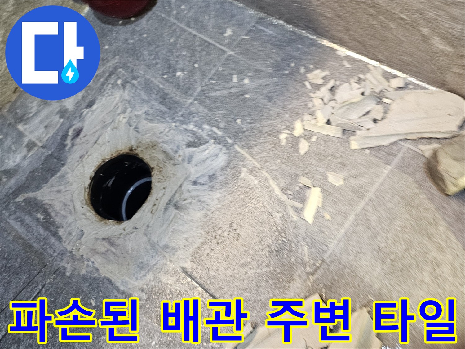 오수관 주변의-깨진 타일과 노출된 배관 입구 모습