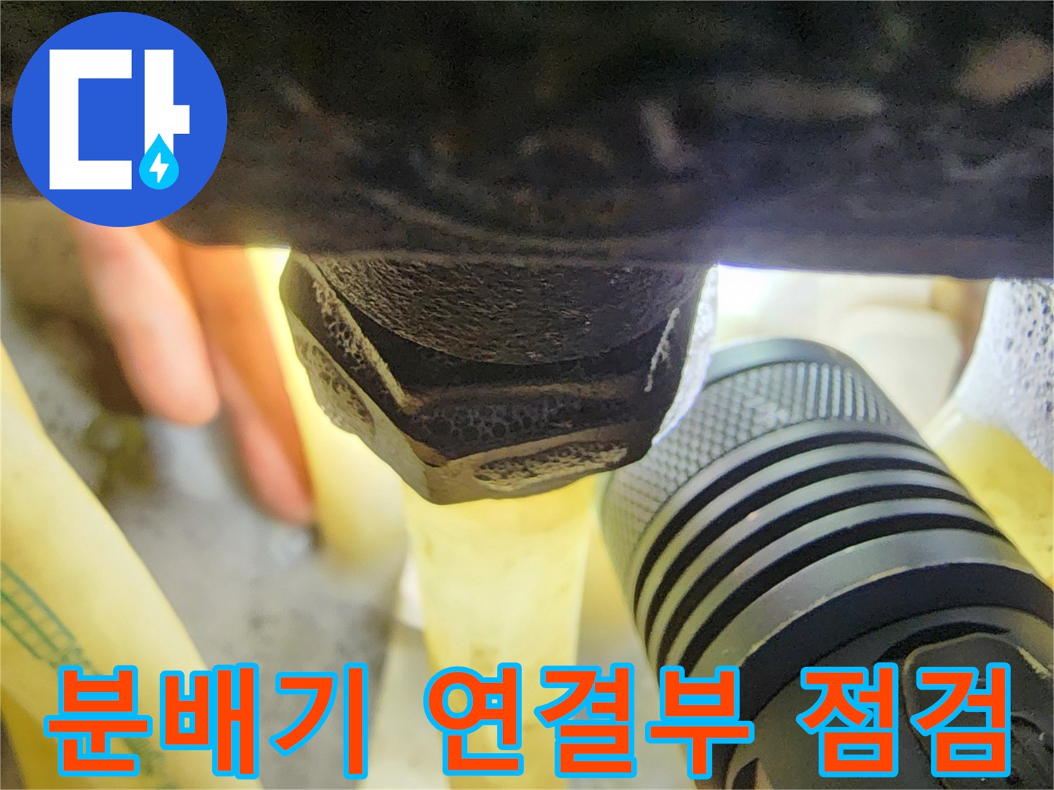 손전등으로 비춘-싱크대 아래 분배기 배관 연결 부위