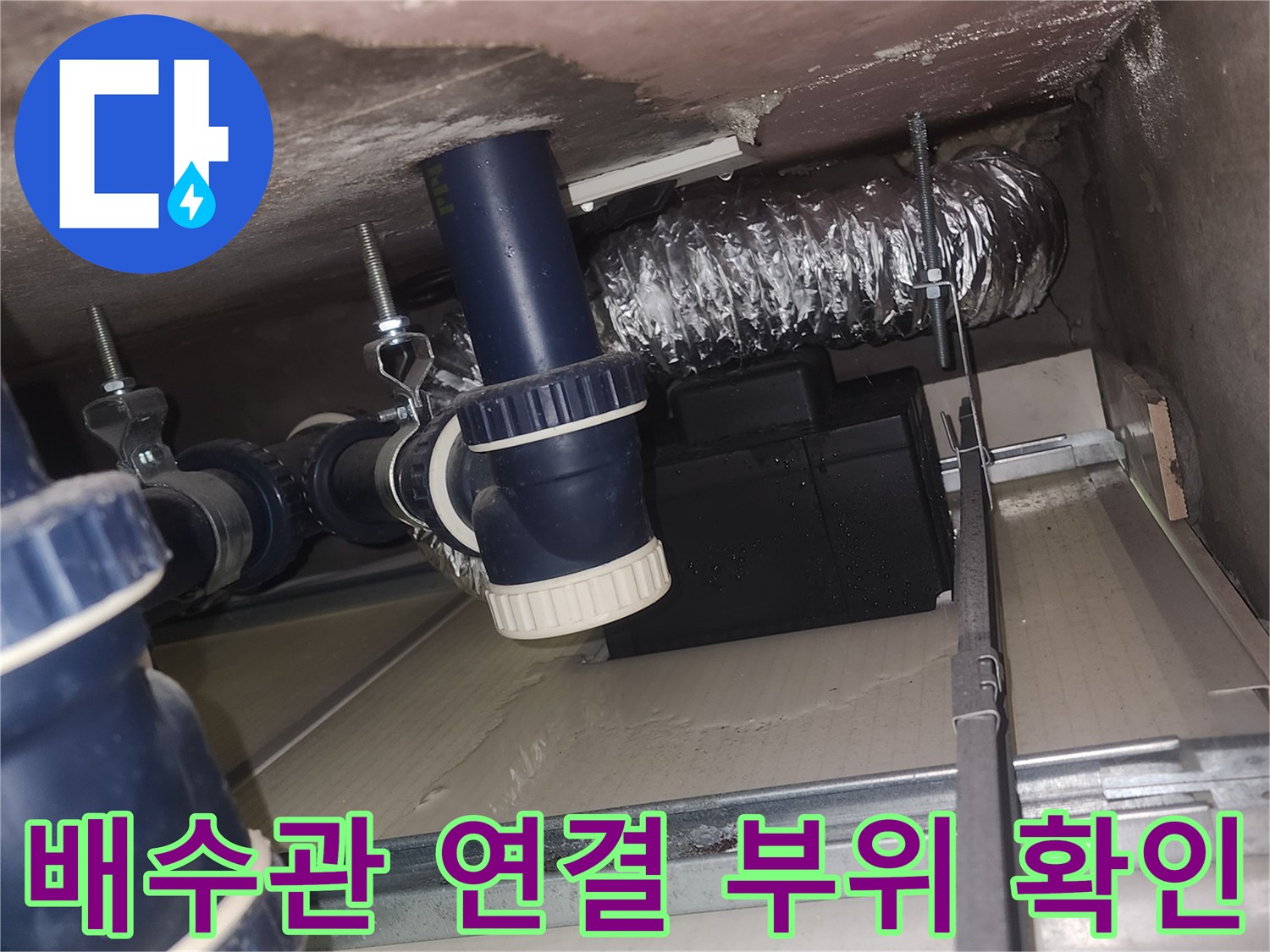 천장 내부 파란색 배수 부속과 은박 단열 배관의 접합부