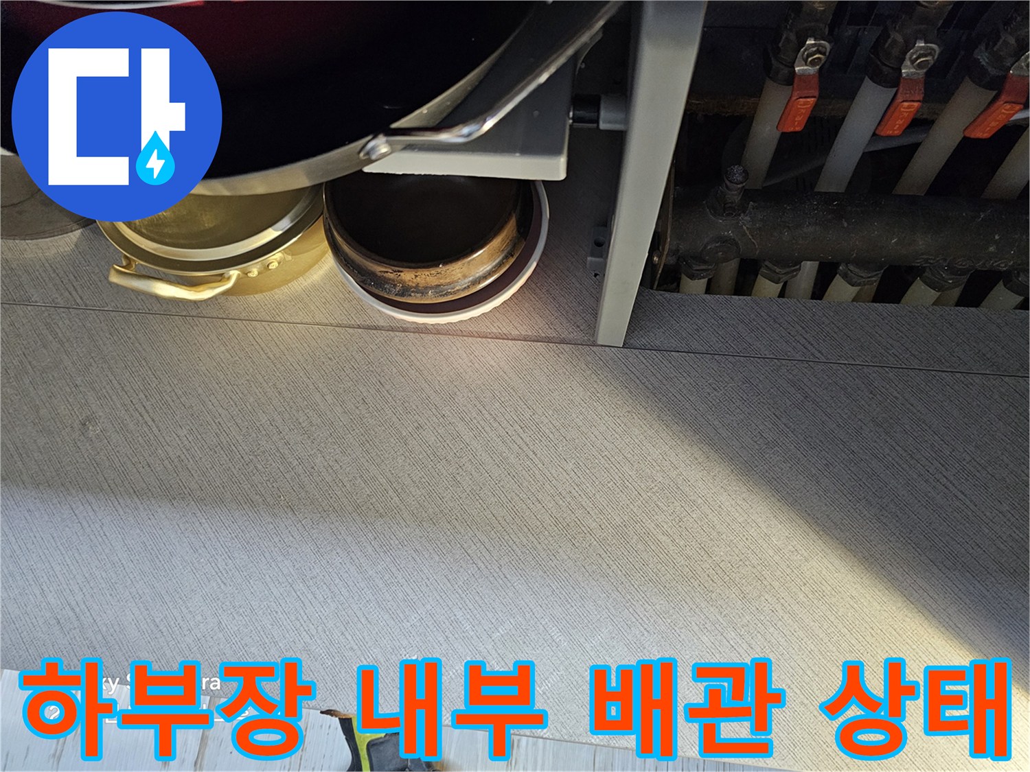 싱크대 아래쪽 수도 부속과 연결된 밸브 및 배관