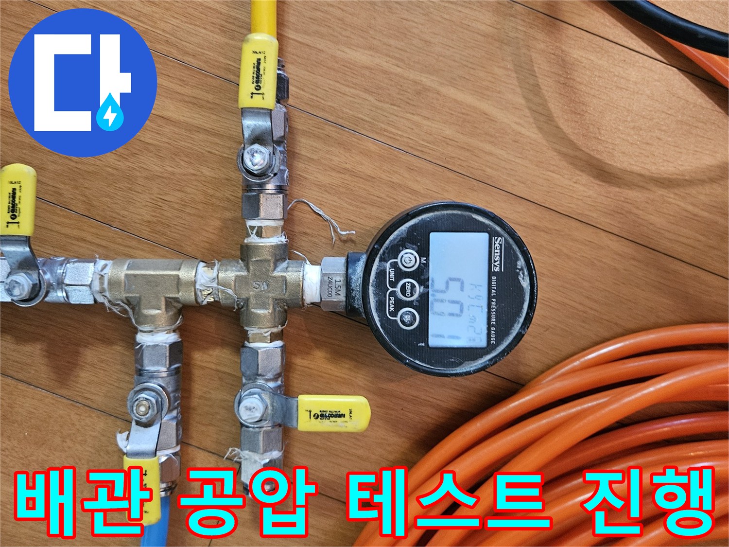 노란색과 파란색 호스가 연결된 배관 매니폴드와 압력 측정 장치