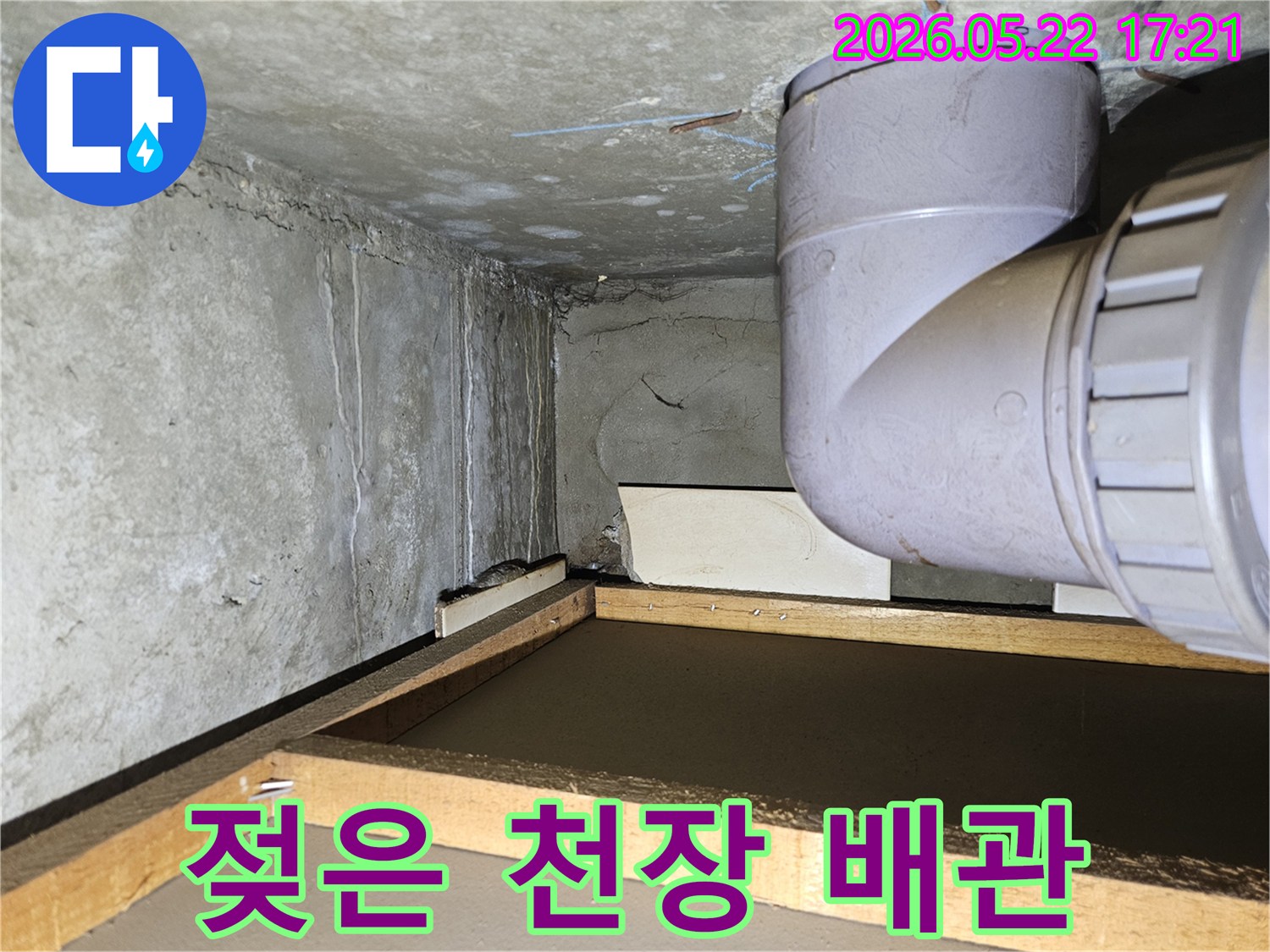 아파트 천장 모서리 부분에 나타난 물 얼룩과-배관 주변의 습기로 인한 누수 상황을 담고 있습니다.