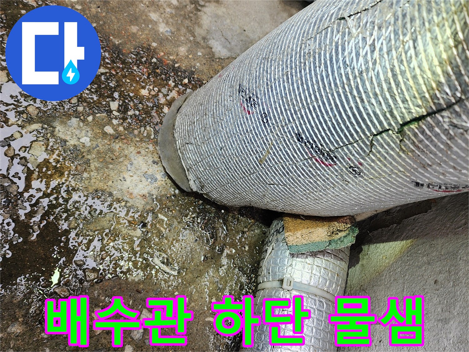 물샘이 진행 중인 배수관 접합부 - 바닥의 젖은 흔적과 오염된 상태
