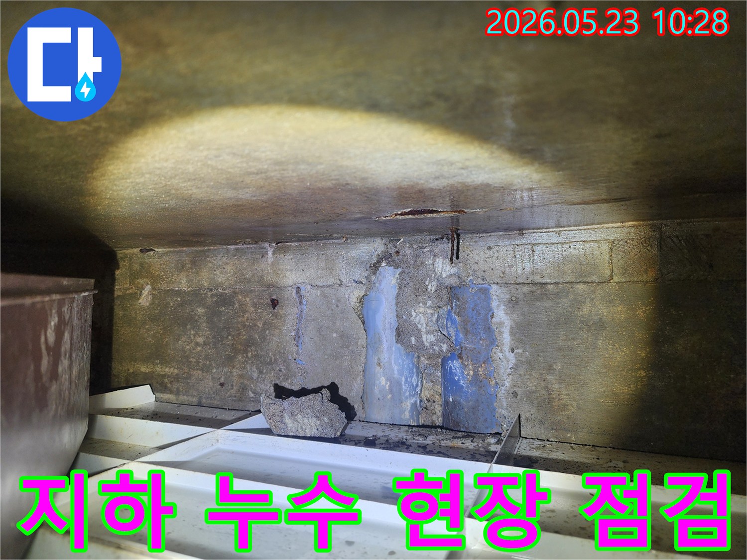 어두운-지하-공간에서-천장과-벽면의-심각한-누수-흔적을-조사하는-전문가의-모습