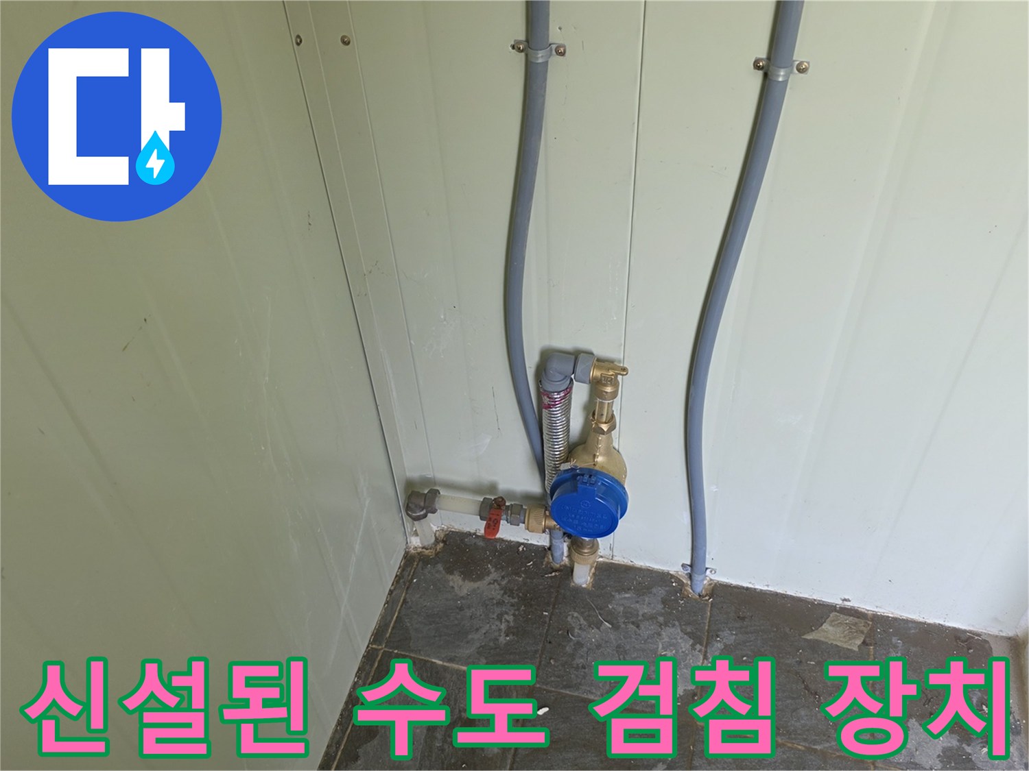 벽면 배관 끝에 설치된 파란색 수도 계량기