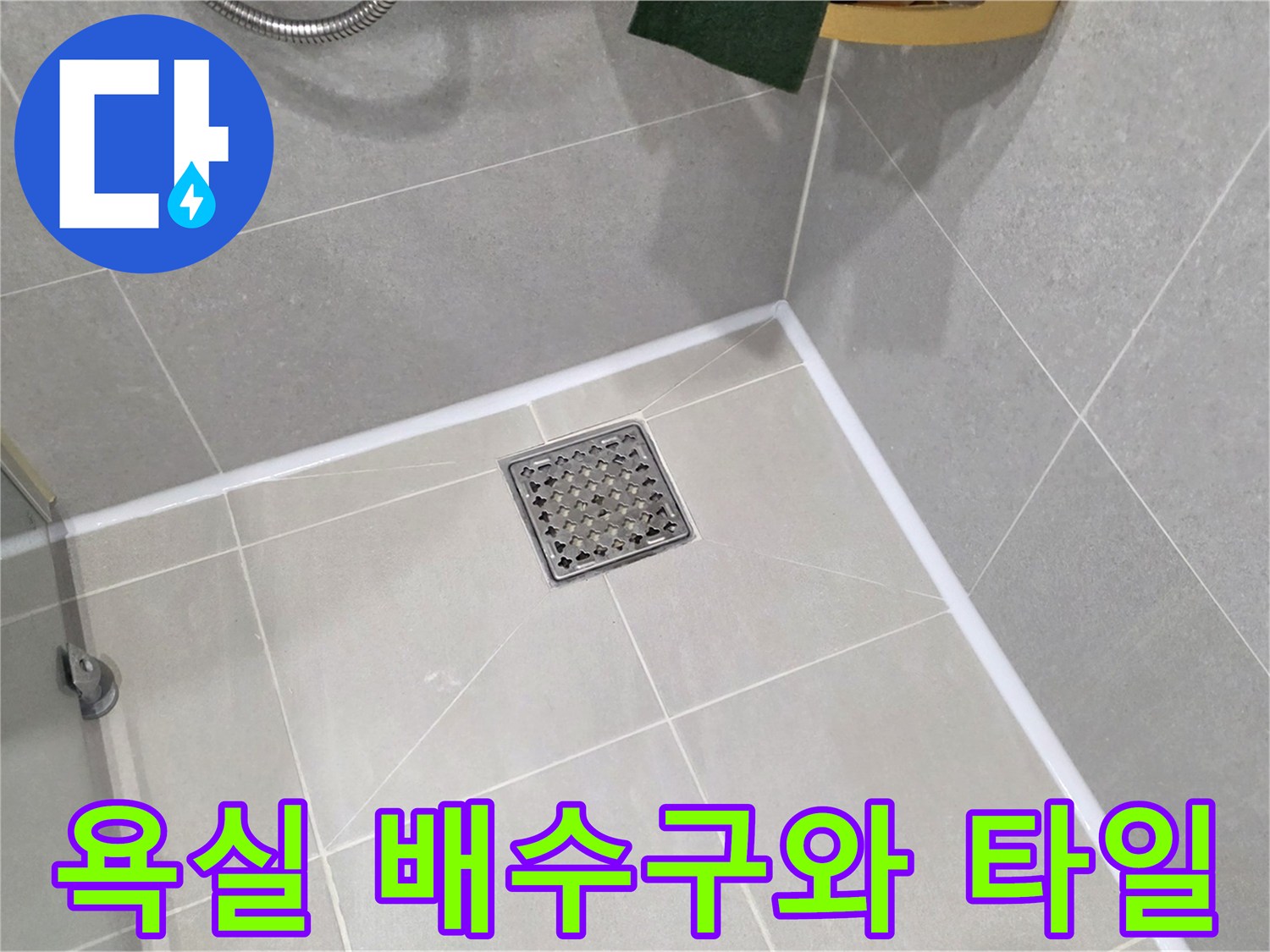 밝은 회색 타일로 마감된 욕실의 배수구 근접 사진
