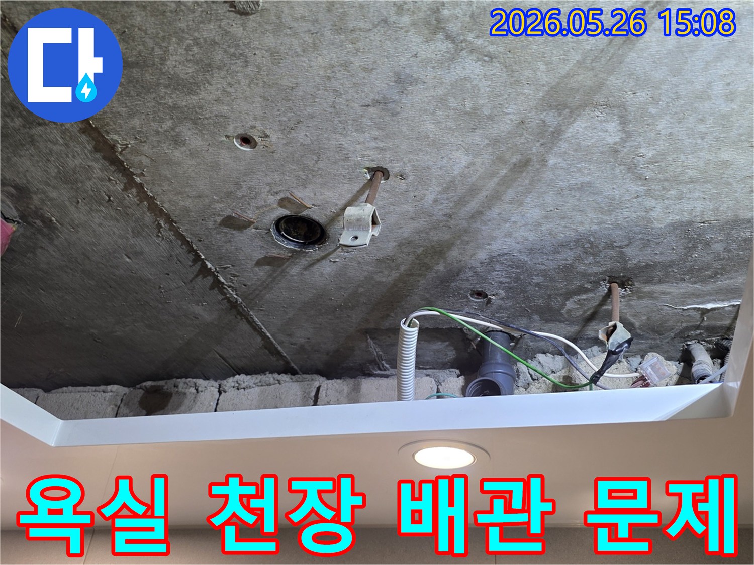 욕실 천장 아래-노출된 배관에서-누수가-발생하여-점검 중인-장면입니다