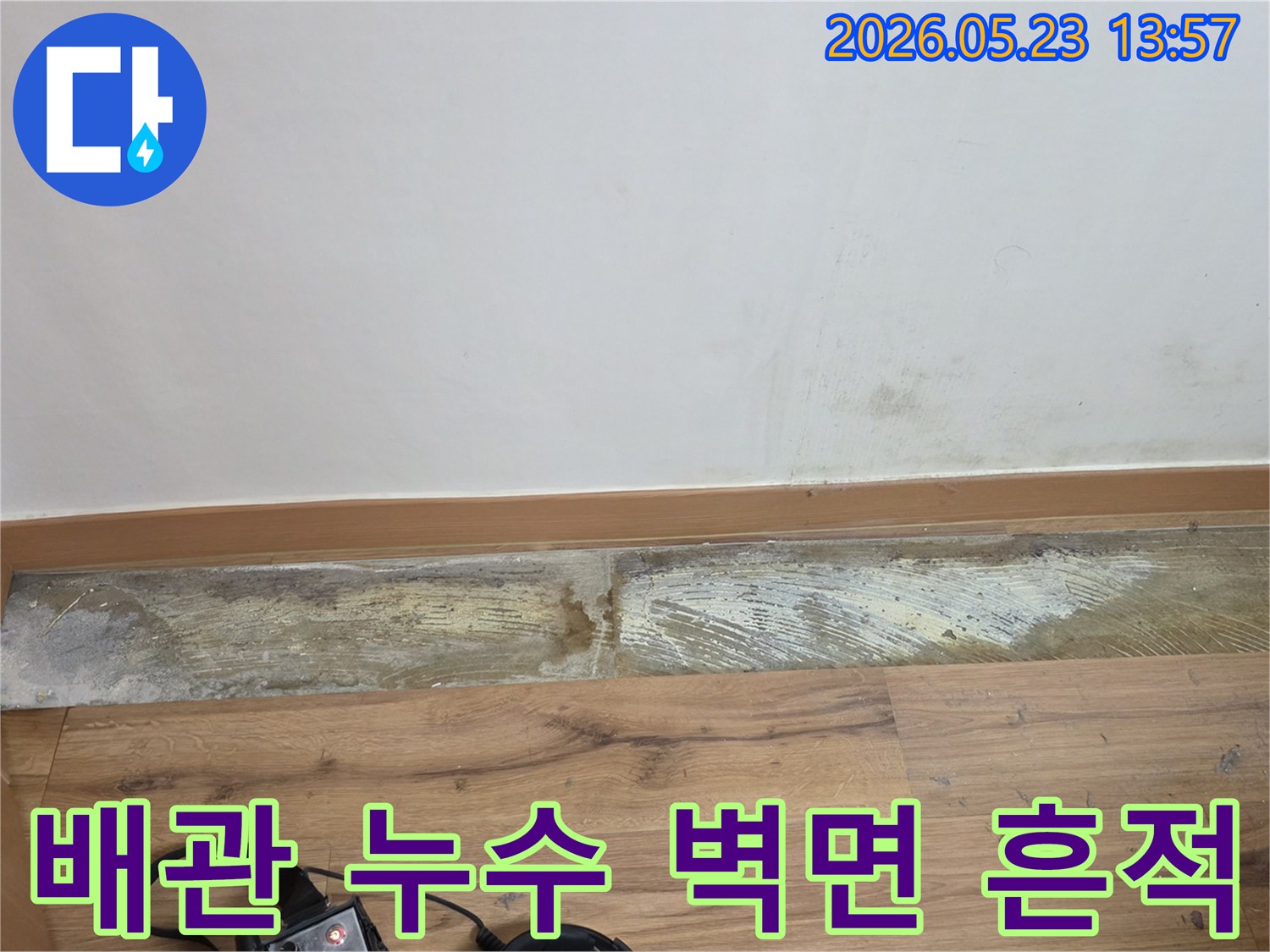 누수로 인해-벽 하단에-발생한-습기와-곰팡이-그리고-변색된-벽면의-상태를-보여주는-현장 이미지