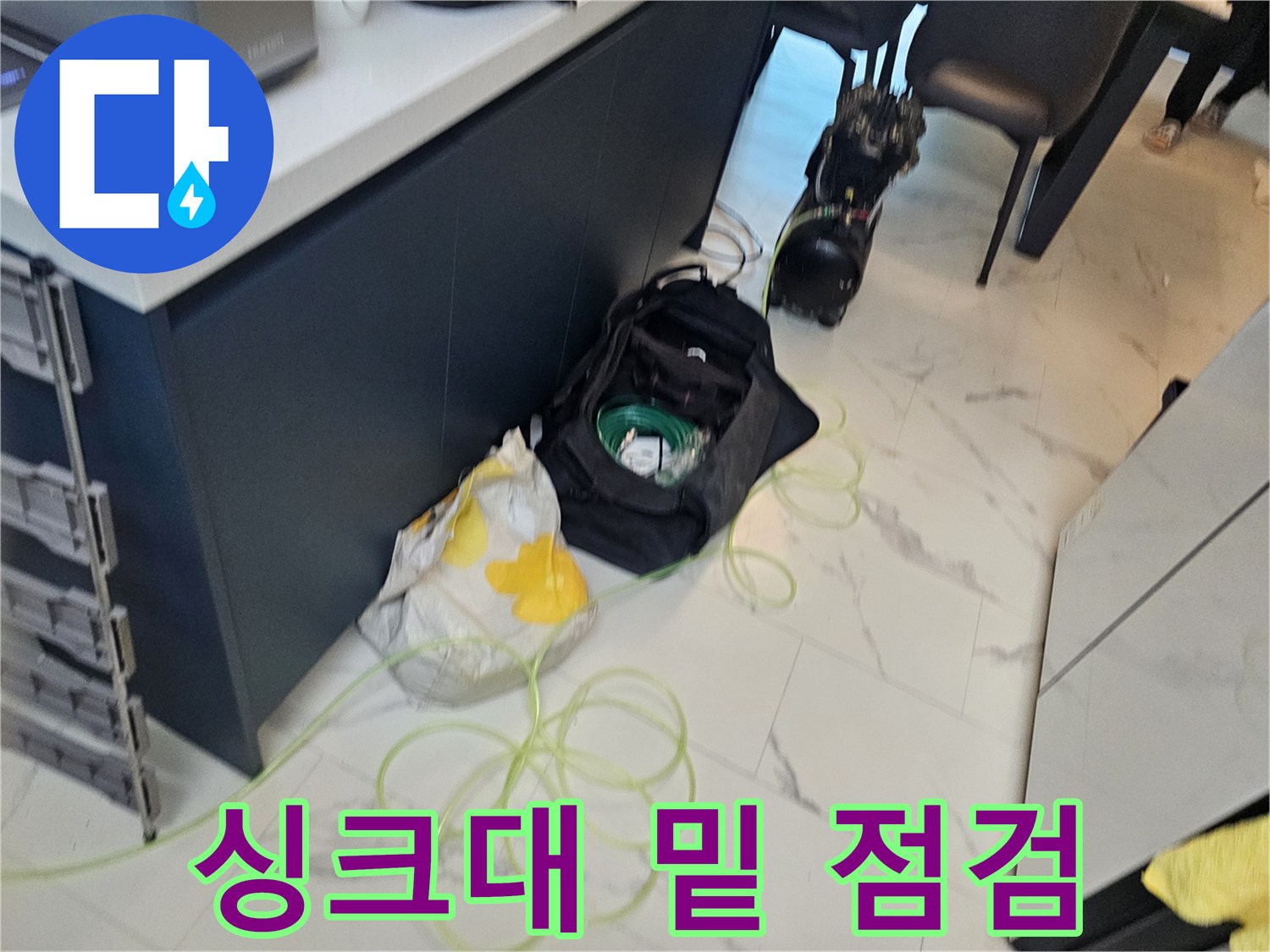 싱크대 아래 배관 연결 부위를 면밀히 관찰하는 모습입니다.