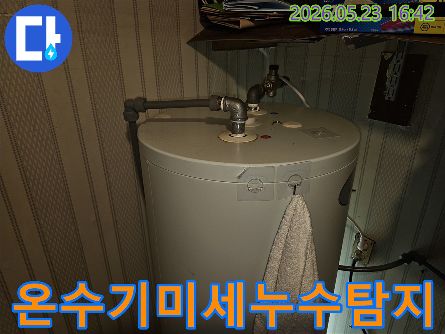 온수기-상단-배관-연결부의-미세한-누수-여부를-전문가가-정밀하게-탐지하는-모습입니다