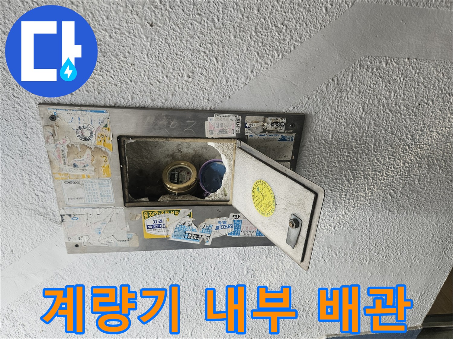 계량기함 덮개 아래로 보이는 수도 계량기와 연결 관로