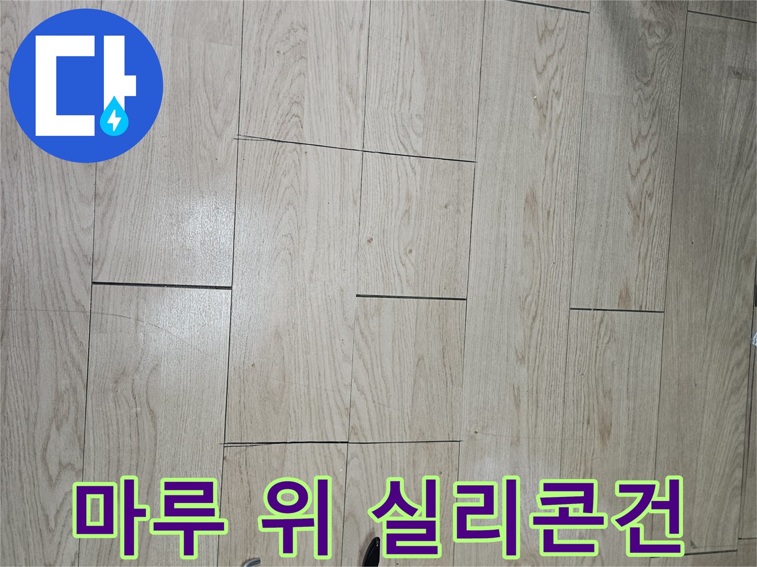밝은색 나무 마루와 검정색 실리콘 주입 도구