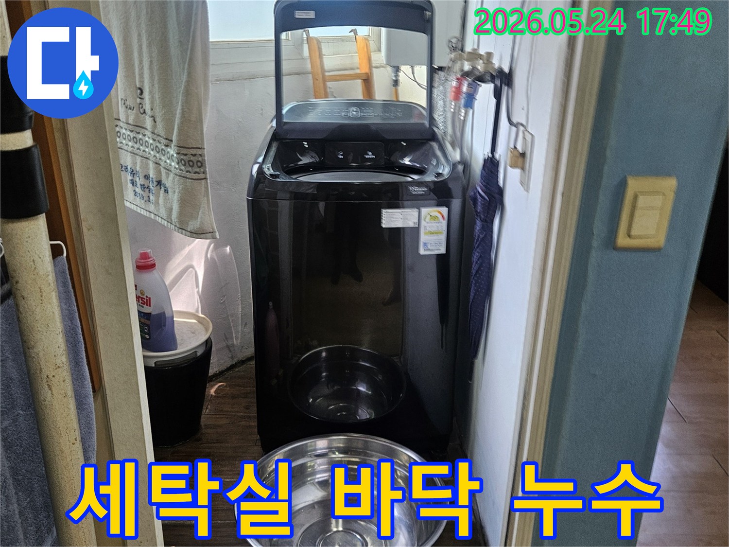 세탁기 옆에-놓인 양동이가-물이 새는-현장을 임시 조치한-사진