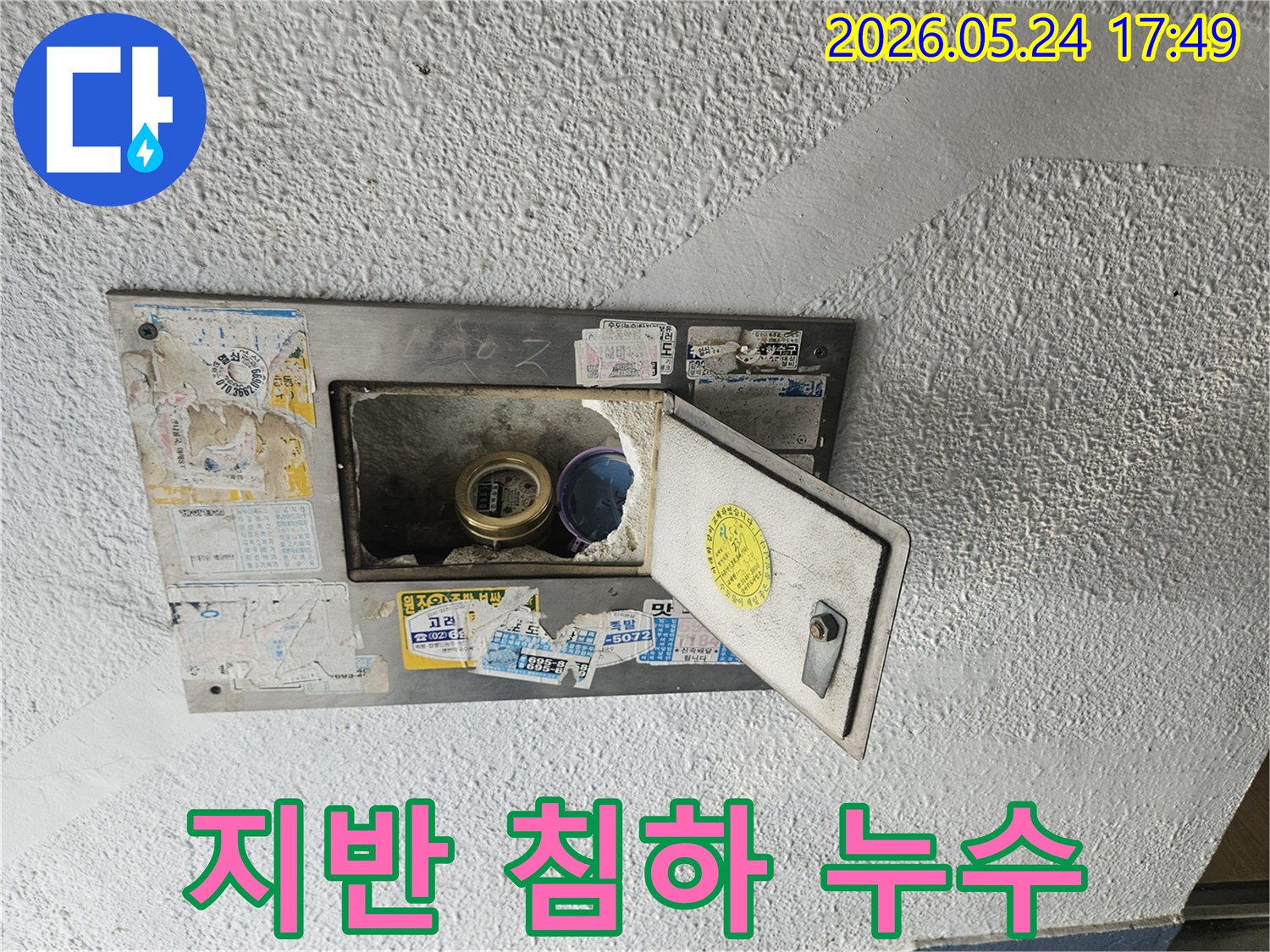 수도계량기함 주변 지반이 침하되어-배관에 무리가 가해져 누수가 발생한-현장을 보여주는 사진입니다.