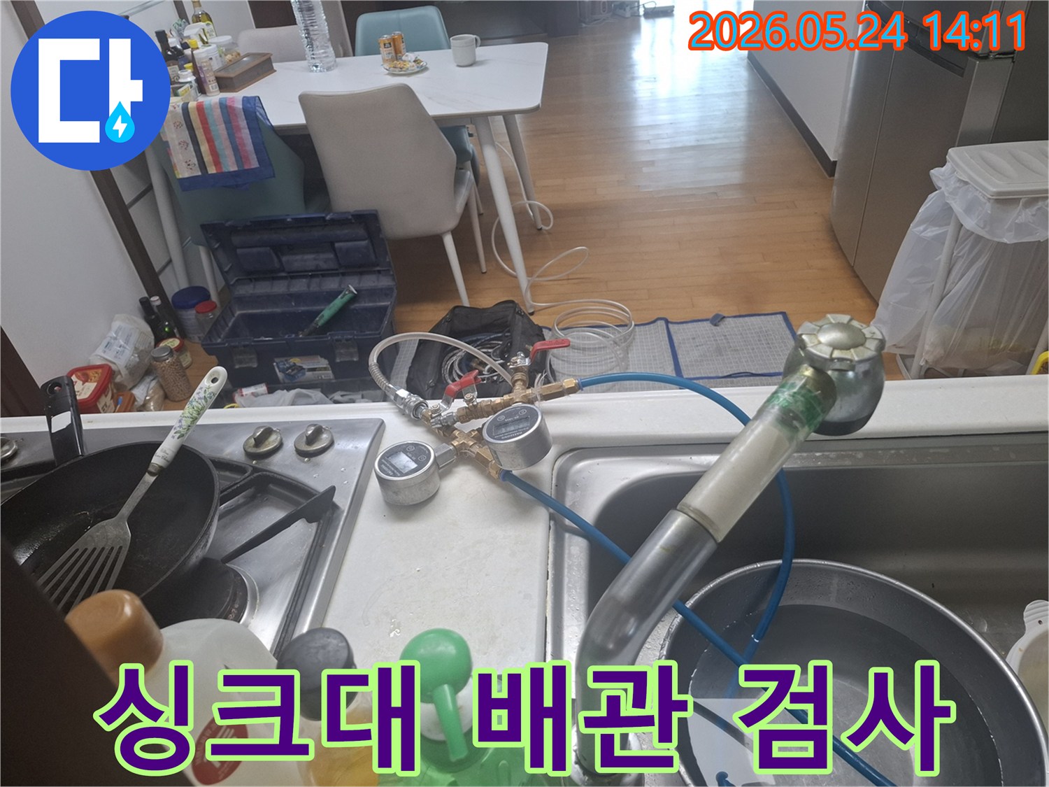 싱크대 아래 배관에서 발생할 수 있는-누수 문제를-해결하기 위해-전문 장비로-압력 검사를-수행하는-사진입니다