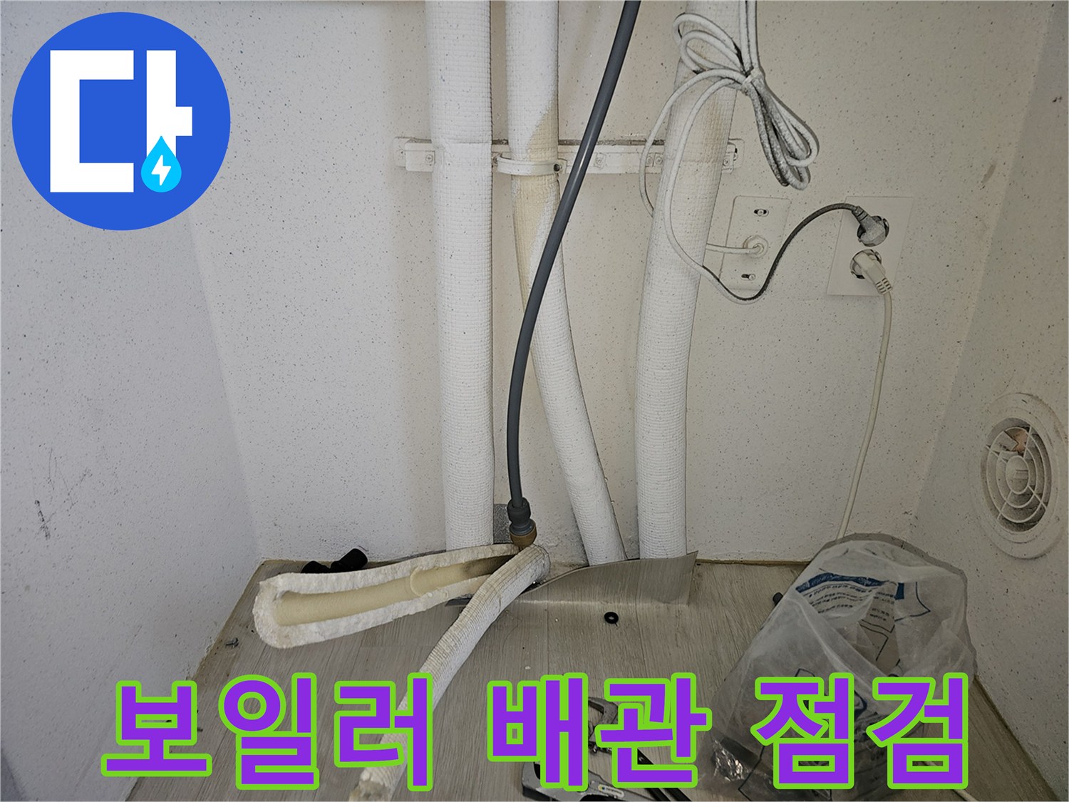 보일러 하단 배관 연결 부위의 누수 상태를 점검하는 모습