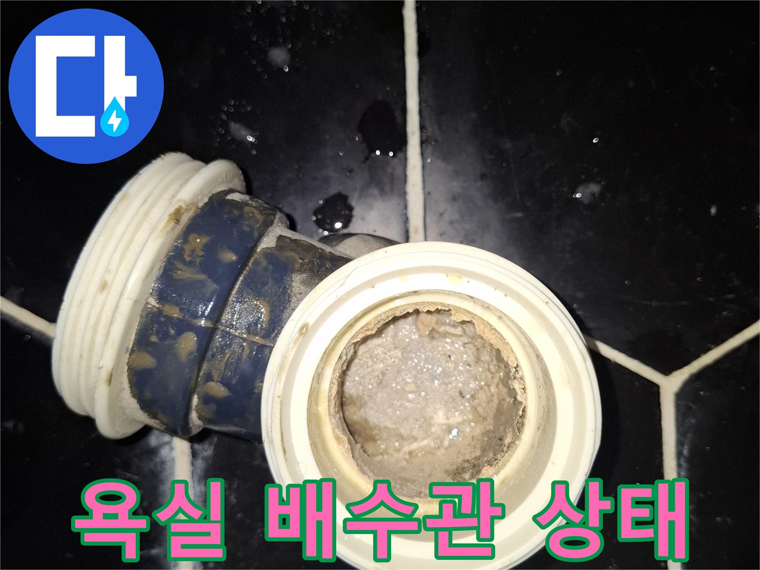 검은색 육각 타일 사이의-노출된 배수관 연결 부위