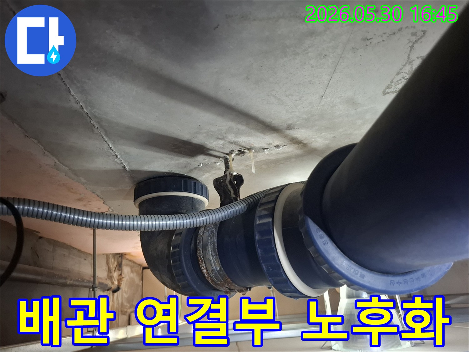 콘크리트 천장 아래-설치된 배관의-연결 부위에서-물이 새어 나와-천장에 얼룩을-만드는 모습입니다.